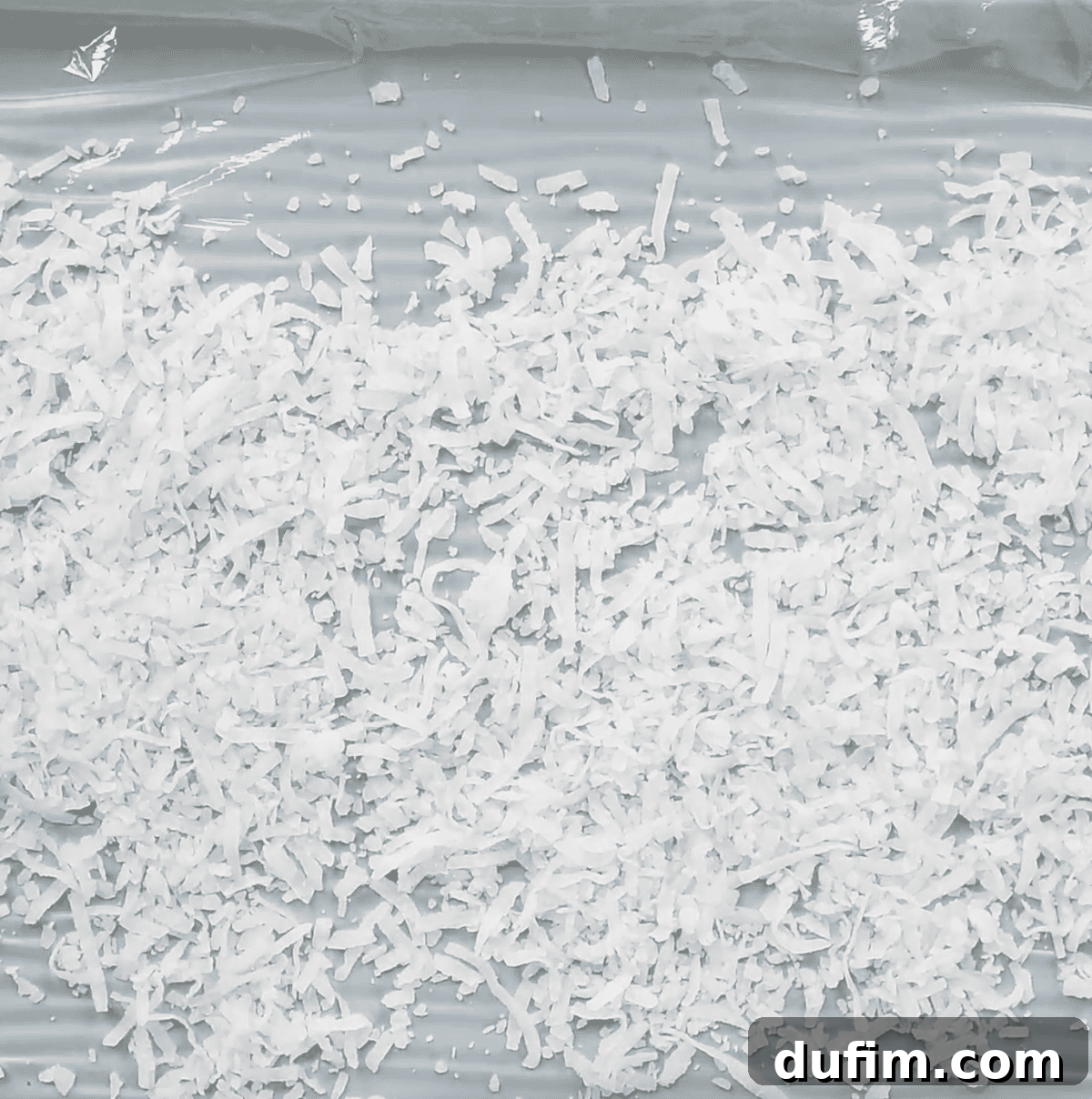 shredded coconut spread over plastic wrap