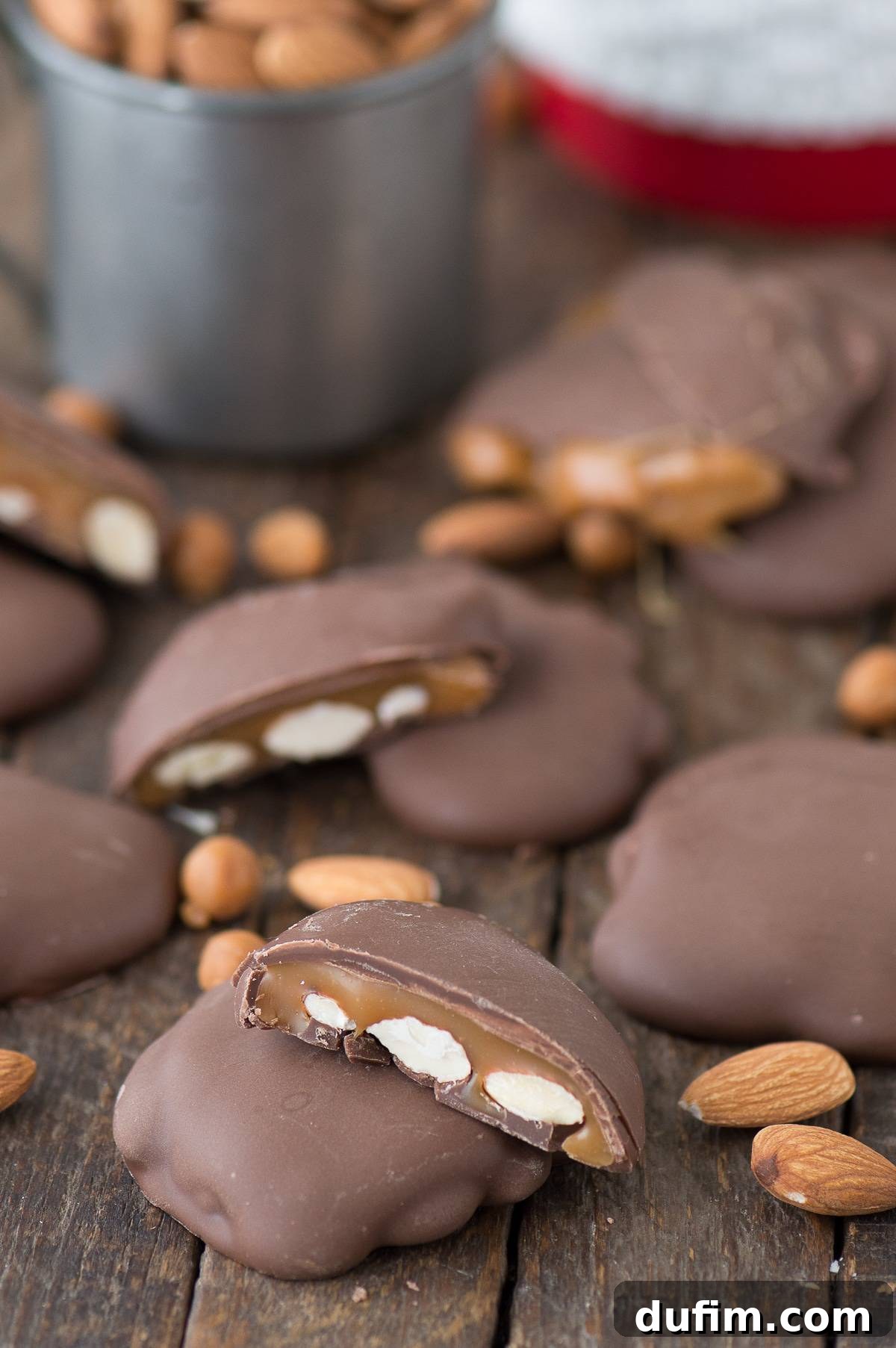 Sticky Paws Williams Sonoma Copycat Christmas candy recipe! Almond caramel clusters dipped in chocolate. Make these at home for a fraction of the price! Five Sticky Paws Williams Sonoma Copycat treats artfully arranged on a wooden table, surrounded by whole almonds, emphasizing their natural appeal.