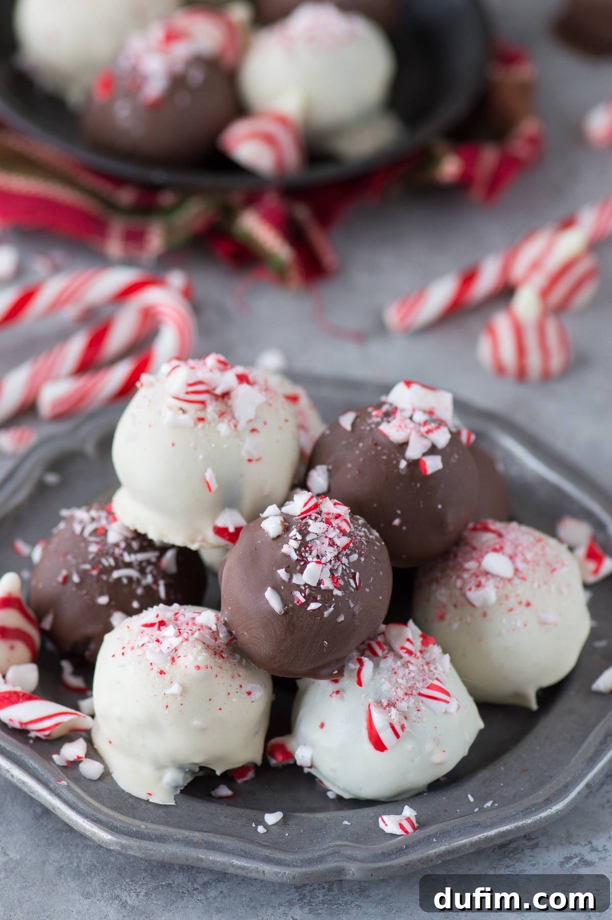A close-up of chocolate and white chocolate Peppermint Oreo Balls beautifully arranged on a metal plate, ready for holiday festivities.