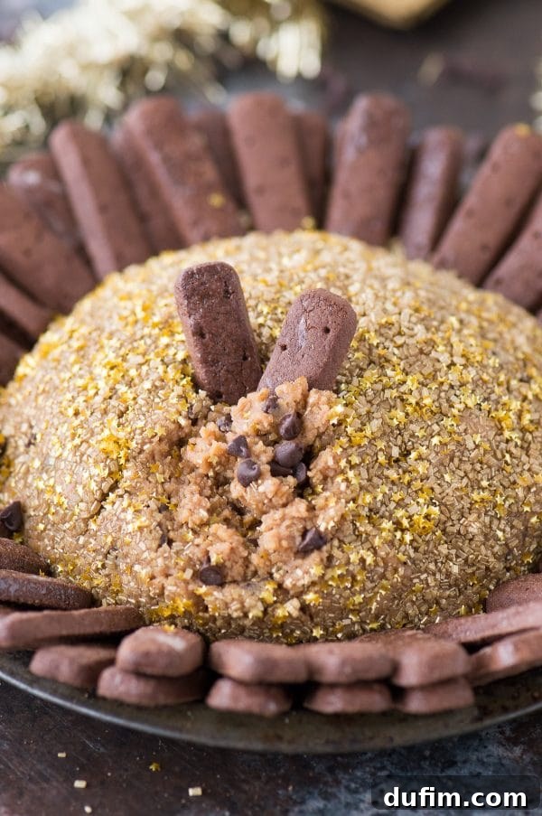 Sparkling New Year's Eve Cheesecake Ball 5 A beautifully presented New Year's Eve cheesecake ball surrounded by chocolate graham cracker sticks, ready for serving.