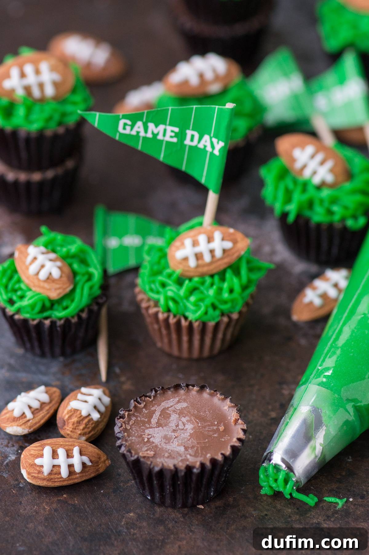 Touchdown Treats Reese Peanut Butter Cups 3 Close-up of Reese's Peanut Butter Football Cups, showcasing the vibrant green frosting and detailed almond footballs ready for a game day party.