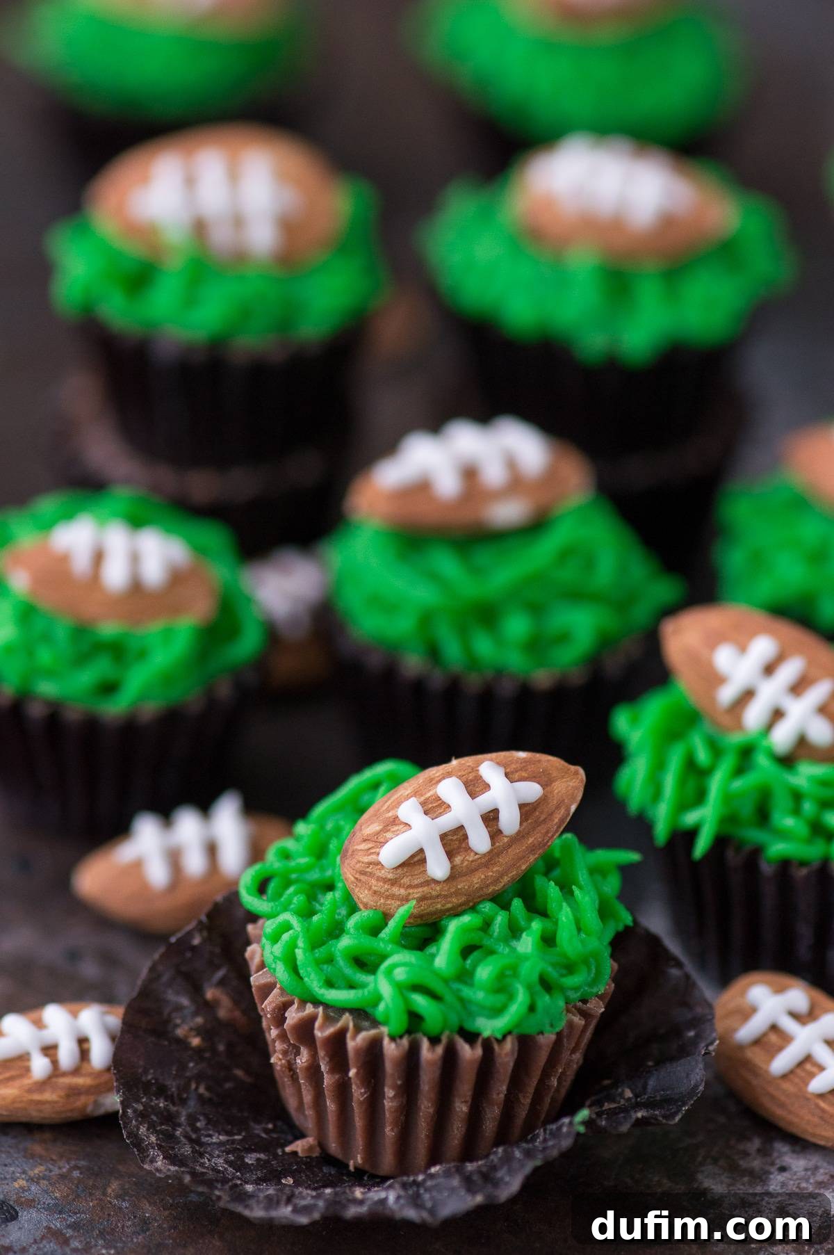 Touchdown Treats Reese Peanut Butter Cups 5 Unwrapped Reese's Peanut Butter Cups beautifully topped with green frosting and football almond decorations, ready for serving at a party.