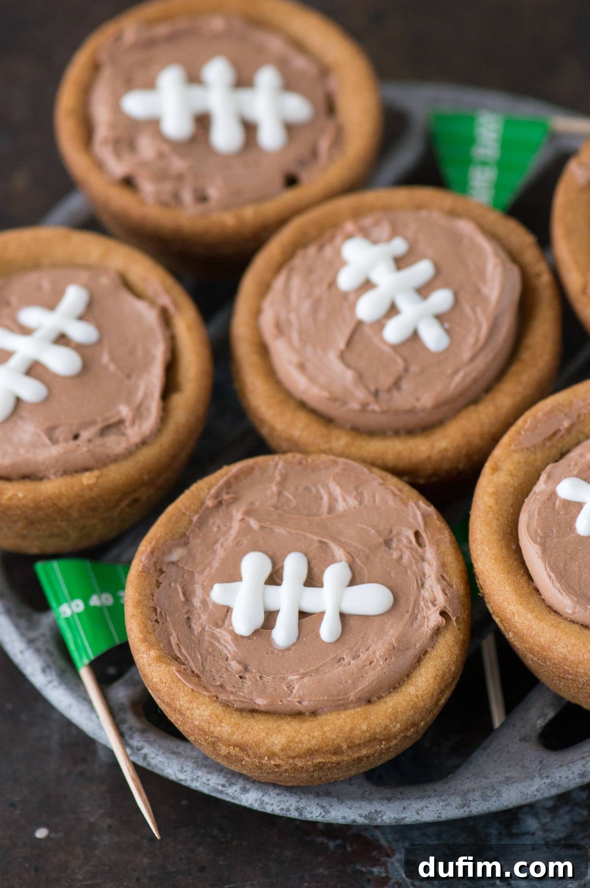 Cheesecake sugar cookie football cups arranged artfully on a serving plate, decorated for a game day party