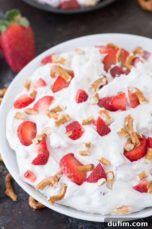 Close-up of a creamy Strawberry Pretzel Fluff Salad, showcasing the smooth texture mixed with fruit and pretzel pieces, perfect for a refreshing treat.