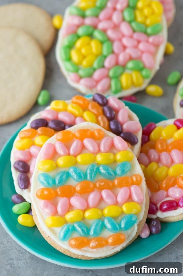 Children's hands carefully placing colorful Jelly Belly jelly beans on a freshly frosted Easter egg cookie, illustrating a fun family decorating activity for kids.