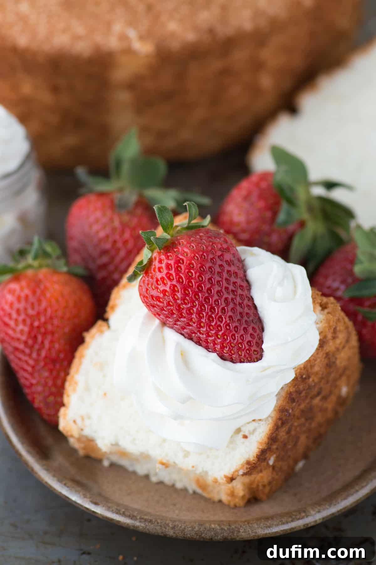 Heavenly Homemade Angel Food Cake 3 A close-up shot of a perfect slice of homemade angel food cake, showing its incredibly soft, spongy interior and golden crust. This simple recipe allows you to bake a classic angel food cake from scratch without special cake flour.