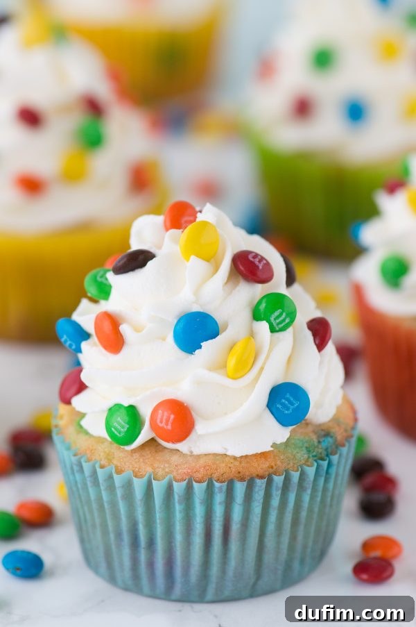 Colorful Candy Cupcakes 2 Loaded M&M cupcakes! Moist vanilla cupcakes with mini M&Ms in the batter, topped with vanilla buttercream and more mini M&Ms!