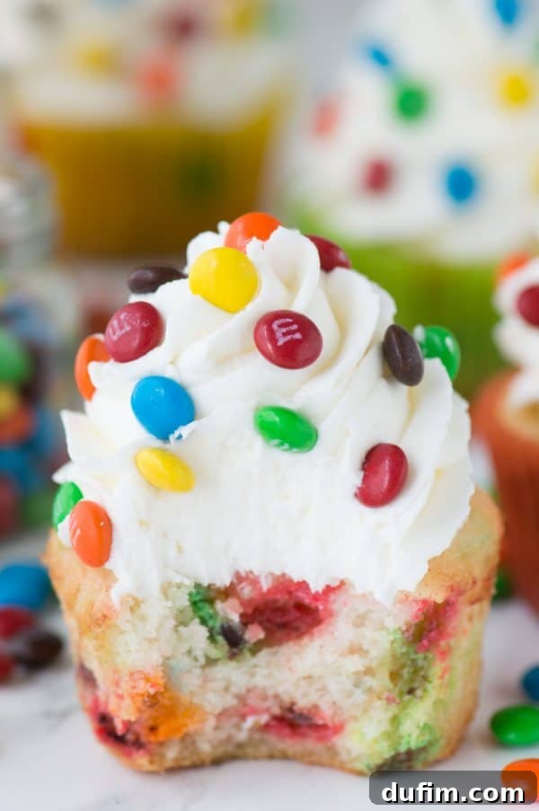 Perfectly frosted M&M cupcakes arranged for a colorful and inviting display, highlighting the vibrant candies.