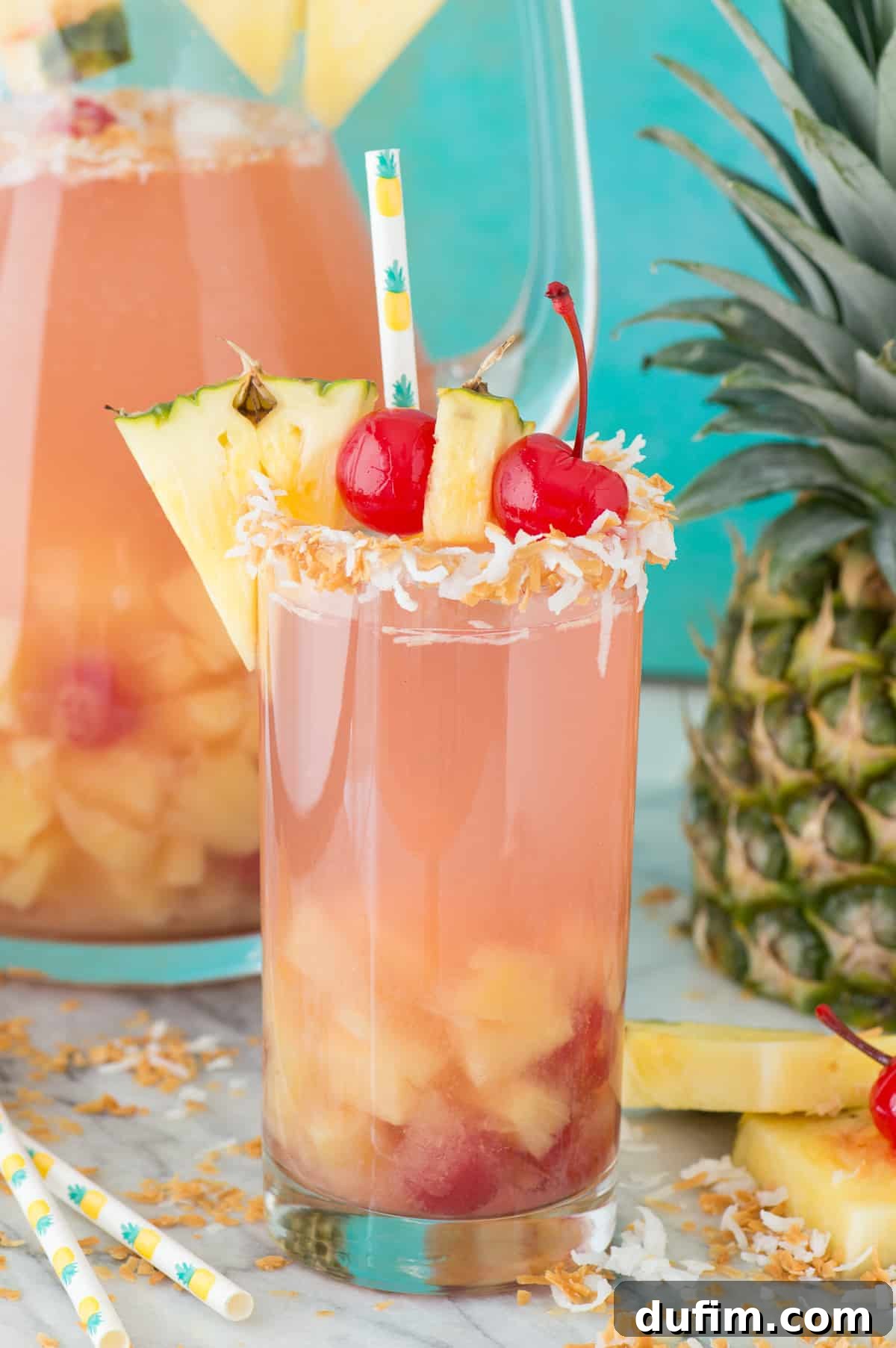 Vibrant Pina Colada Sangria in a glass cup, garnished with fresh pineapple and a cherry, ready for sipping.