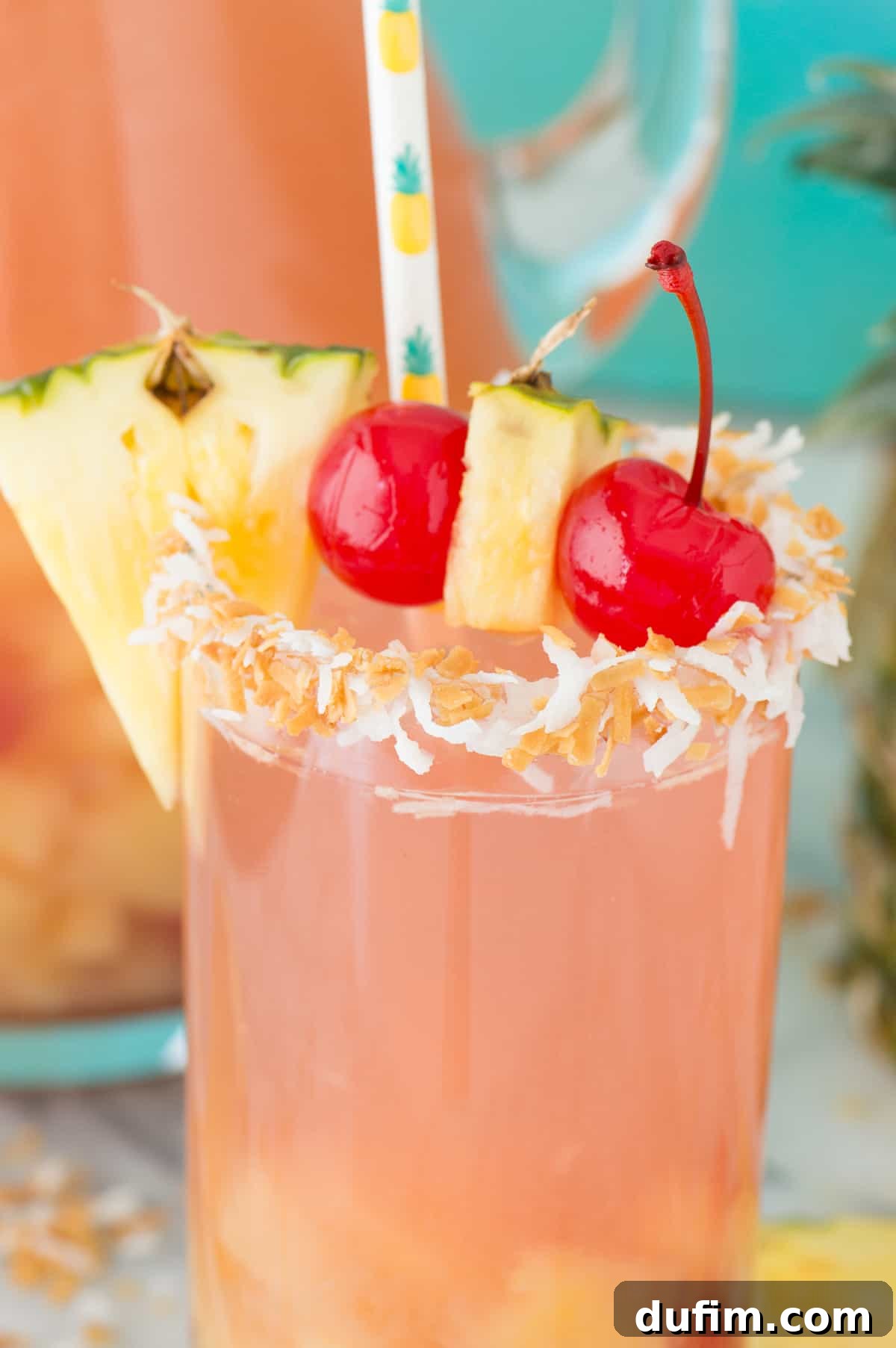 Close-up of Pina Colada Sangria in a clear glass, showing the fruit and vibrant color, with a festive straw.