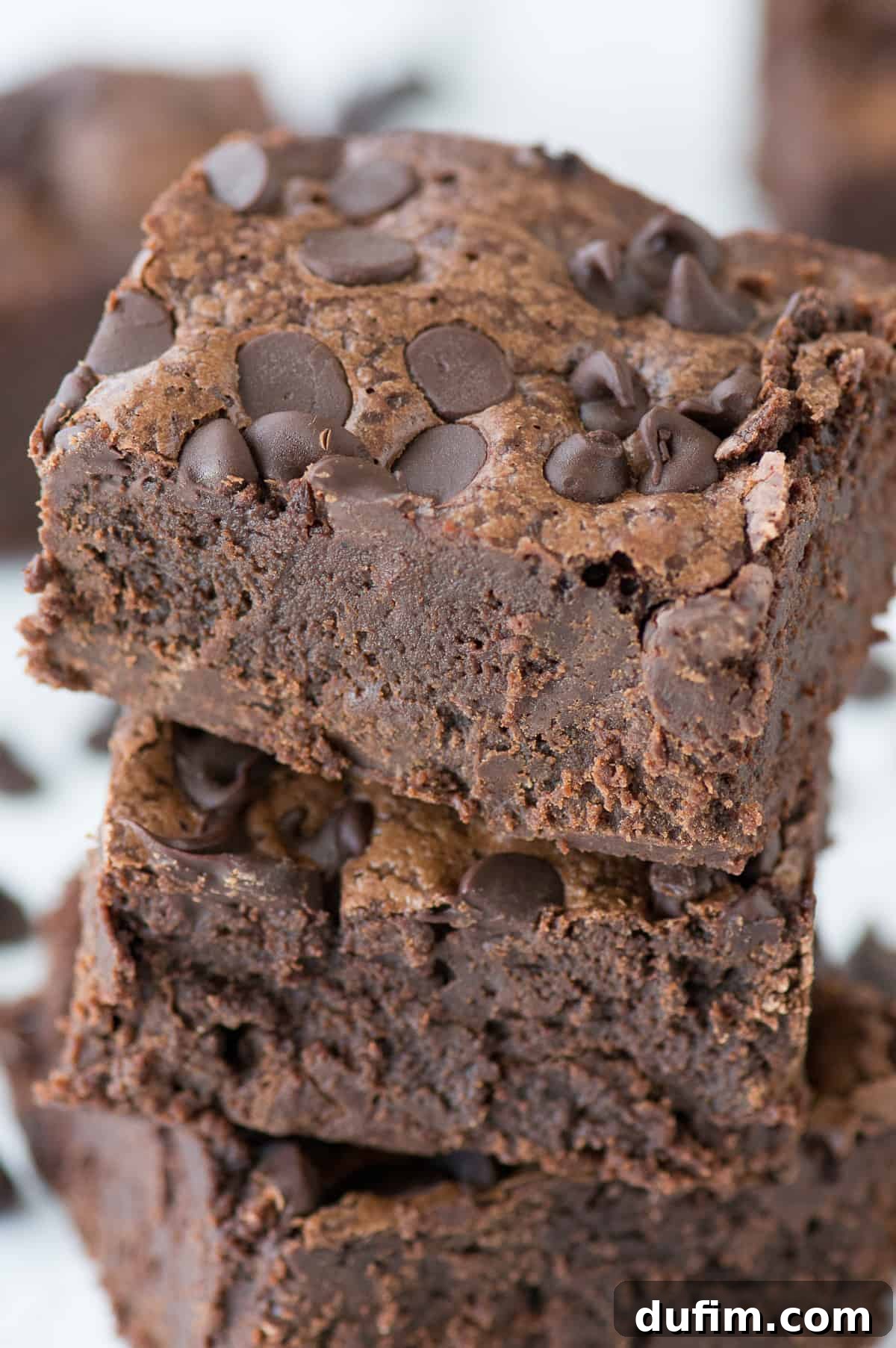 Decadent Fudge Brownies 5 a stack of three decadent super fudgy brownies on a pristine white background