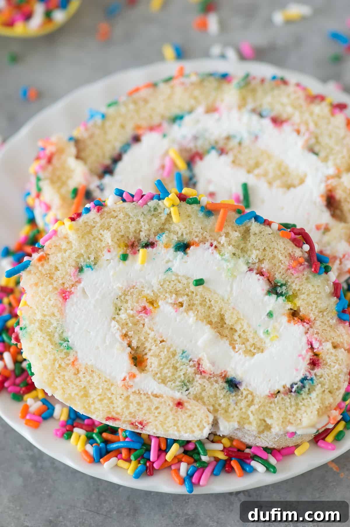 Colorful Confetti Cake Roll 3 Close-up of a Funfetti Cake Roll revealing its soft vanilla sponge, creamy filling, and abundant colorful sprinkles.