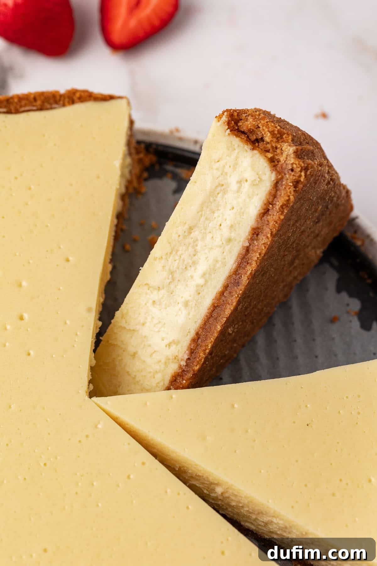 A beautifully presented cheesecake, pre-sliced into individual servings, ready for guests.
