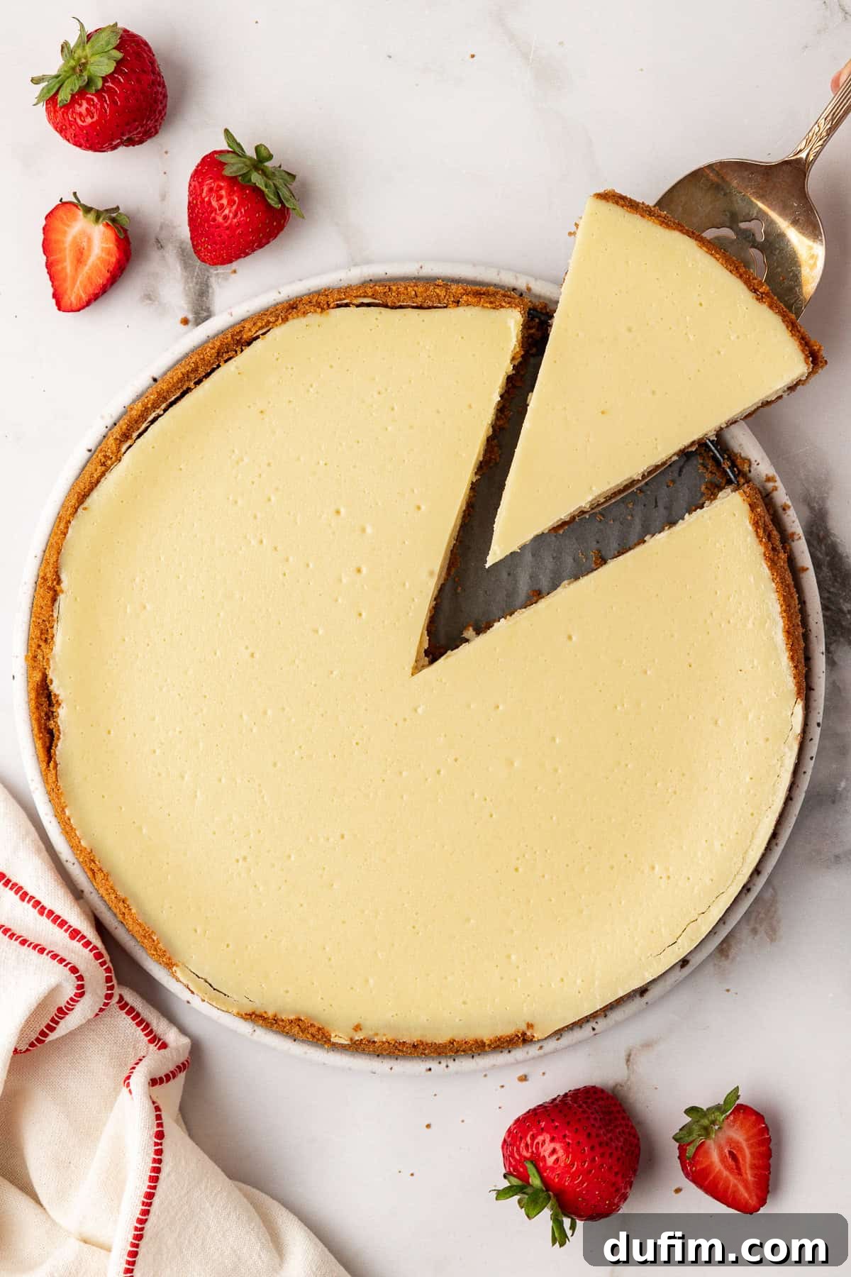 A perfectly cooled and chilled single slice of cheesecake, removed from the larger cake, showcasing its smooth interior and perfect shape.