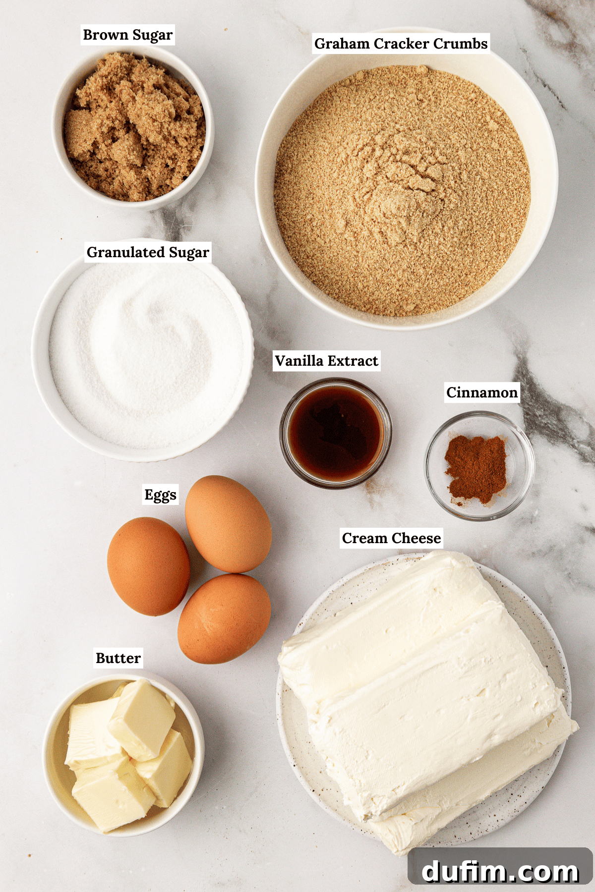 A beautifully arranged collection of fresh ingredients essential for making a delicious classic cheesecake, including cream cheese blocks, eggs, vanilla extract, and sugar.