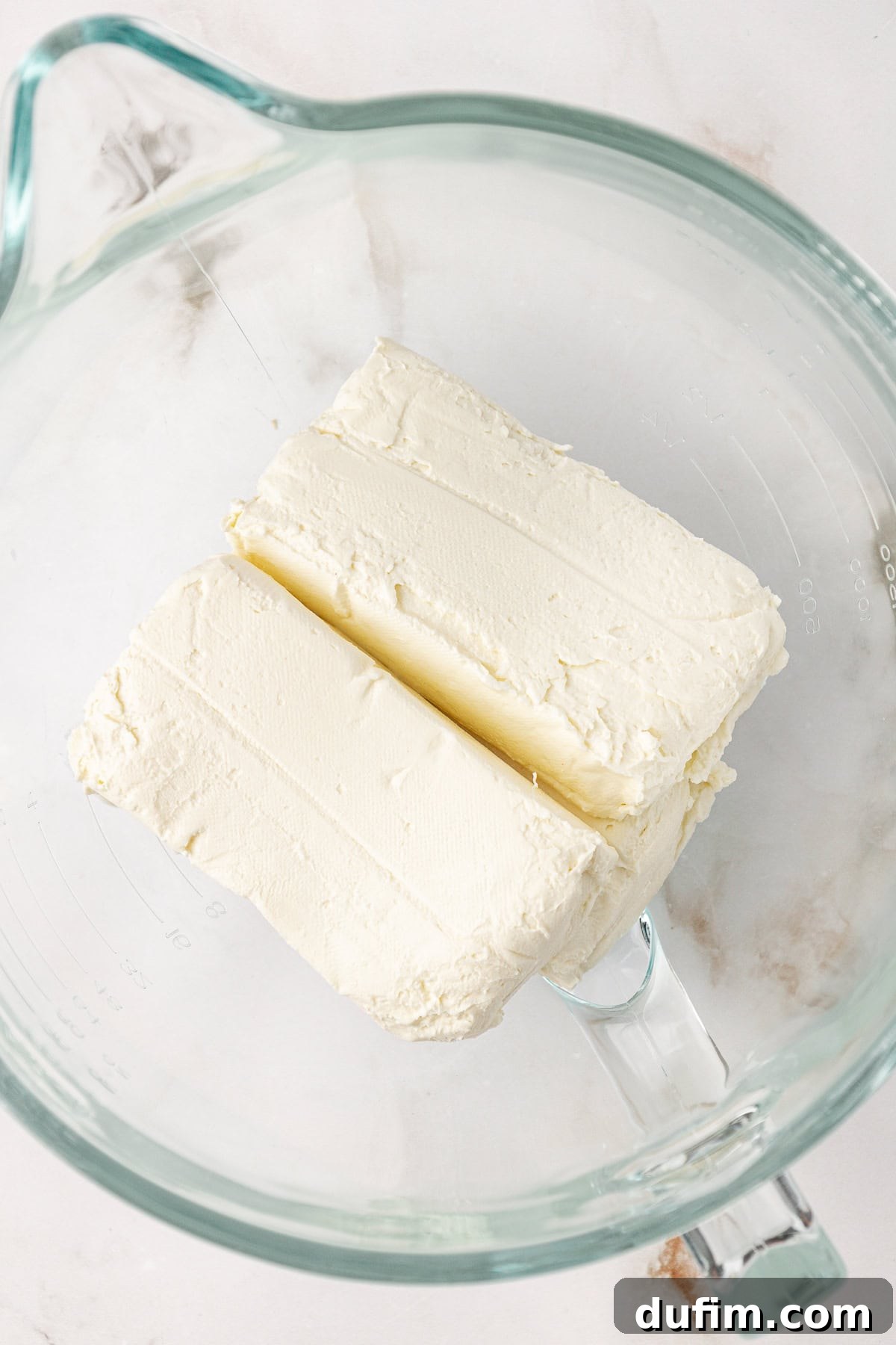 The creamy cheesecake batter being mixed in a large bowl, showcasing its smooth and lump-free texture.