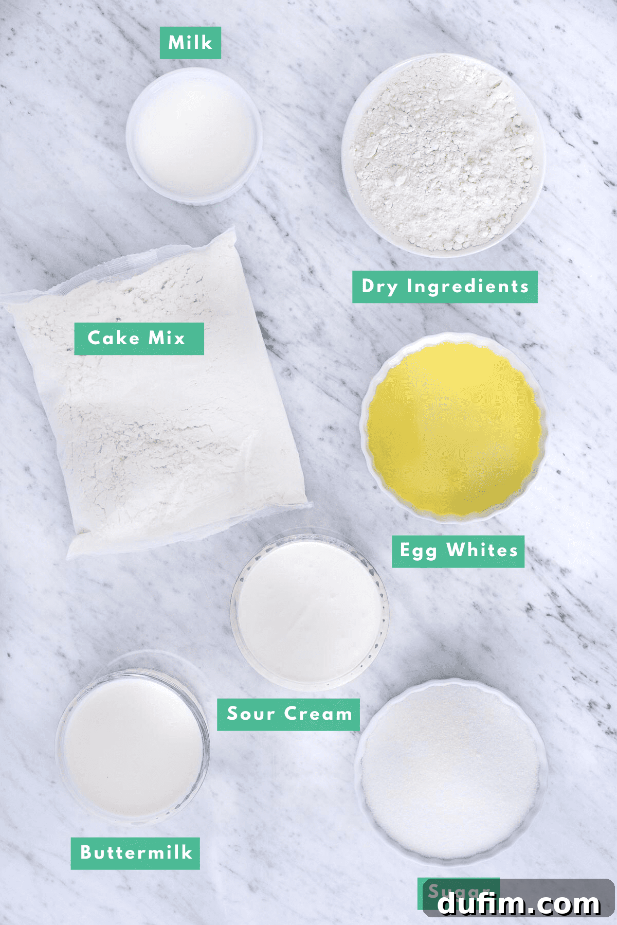Carefully arranged ingredients for enhancing a white box cake mix, including flour, sugar, eggs, and dairy, set against a pristine marble background.