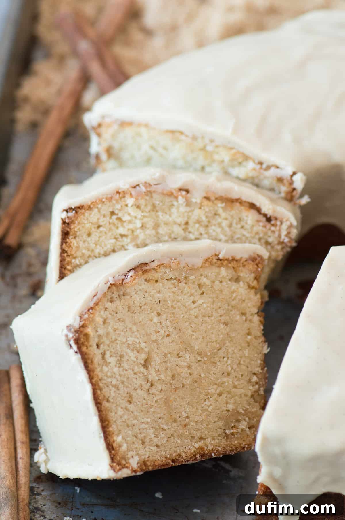 A generous slice of moist brown sugar pound cake on a plate, showcasing its fluffy yet dense texture and the glistening glaze. An ideal comfort food dessert.