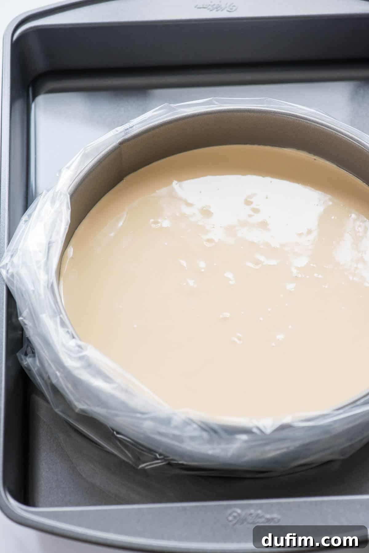 An illustrative image demonstrating how to properly bake a cheesecake using a water bath technique to ensure even cooking and prevent cracks.