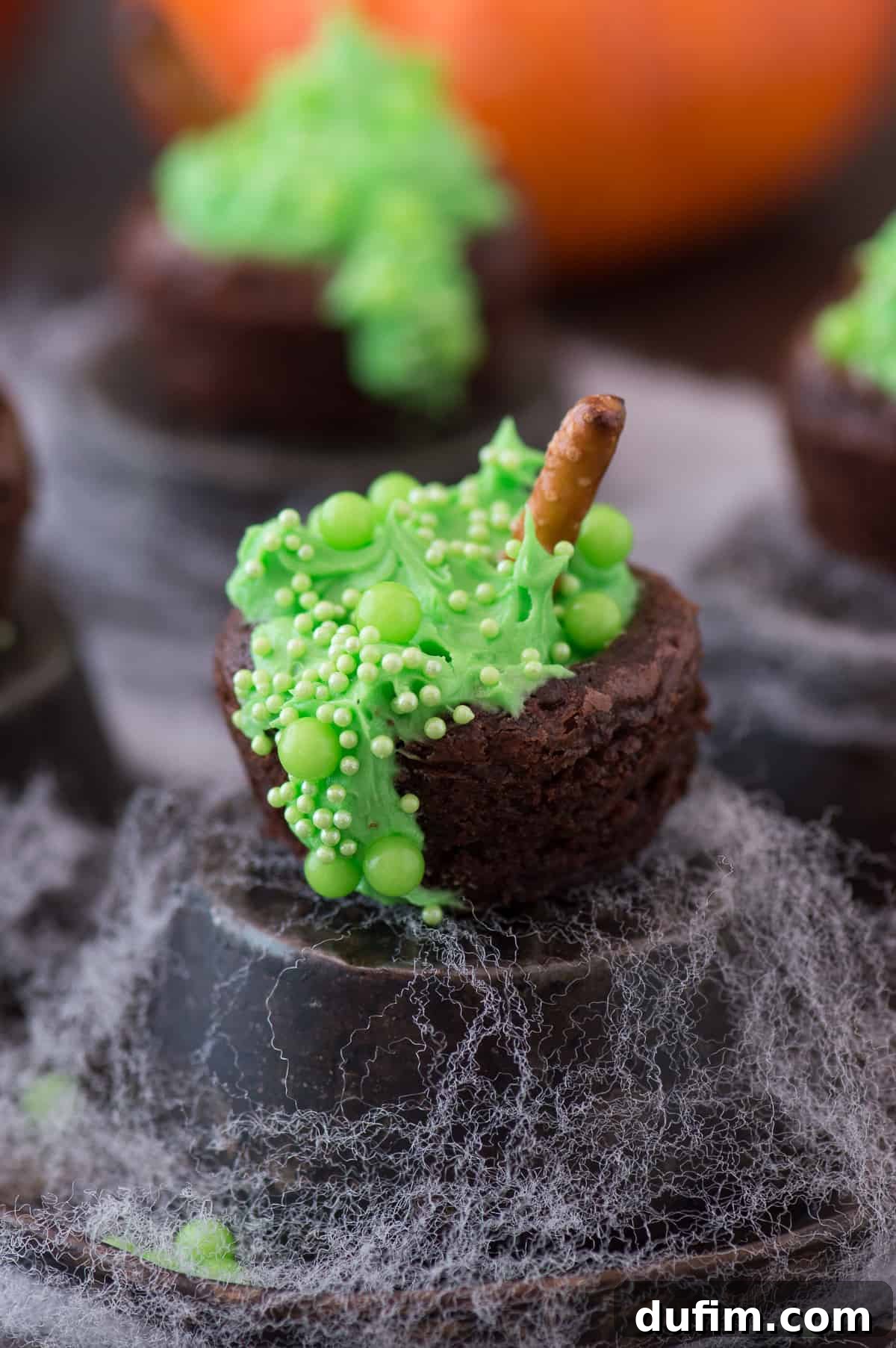 Assorted green sprinkles, green gel food coloring, softened butter, and a bowl of powdered sugar laid out, ready for making the green buttercream for Bubbling Witch's Cauldron Brownies.