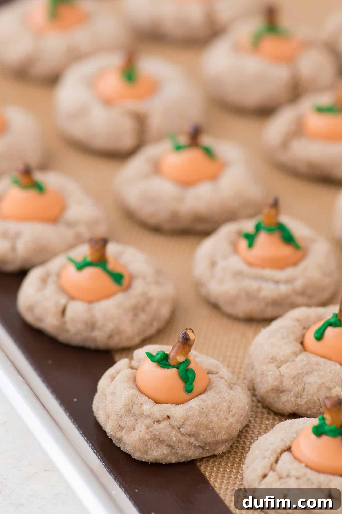 Pumpkin Blossom Delights 3 A stack of freshly baked pumpkin blossom cookies, soft and golden, with the melted pumpkin spice Kisses pressed into their centers, ready for final decoration.