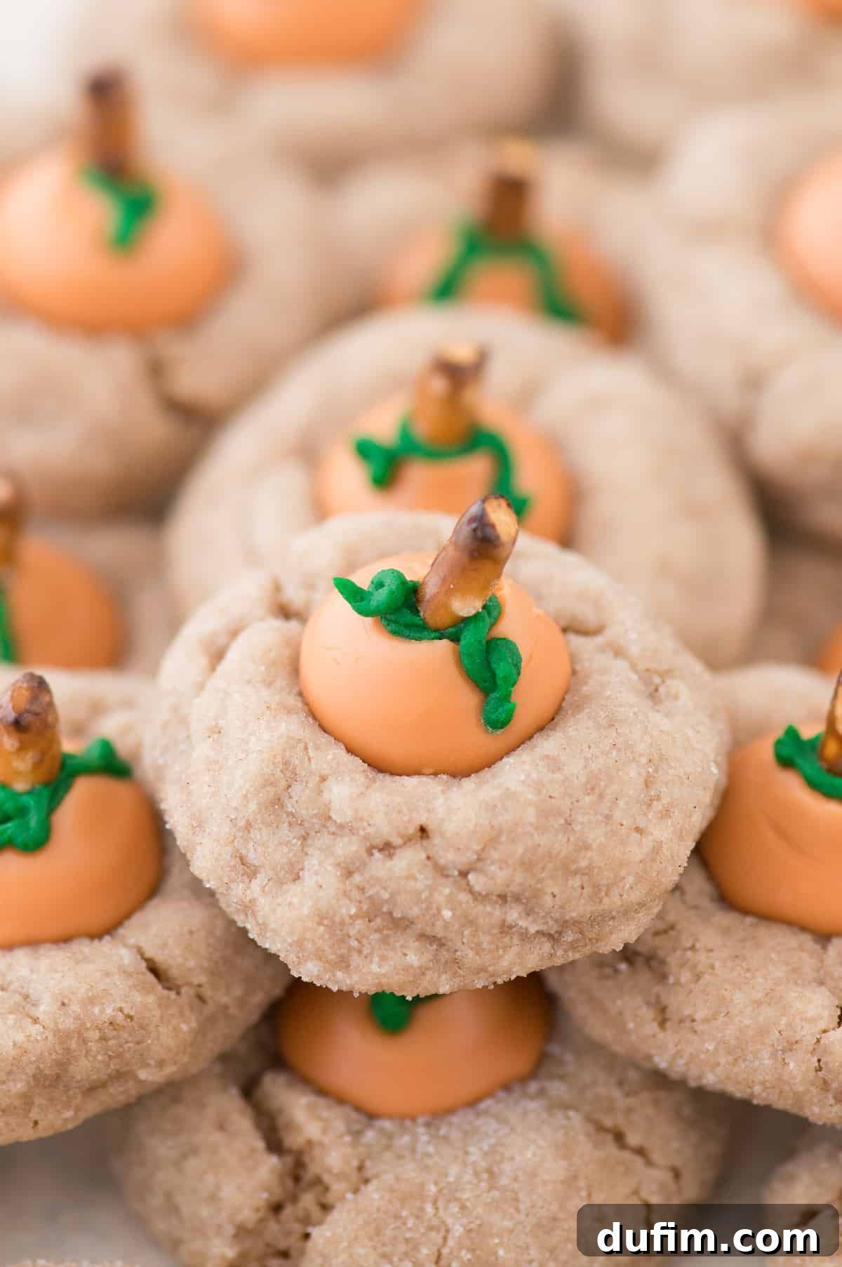 Pumpkin Blossom Delights 4 A close-up of a hand decorating a pumpkin blossom cookie with green buttercream leaves, showing the attention to detail that makes these fall treats so charming.