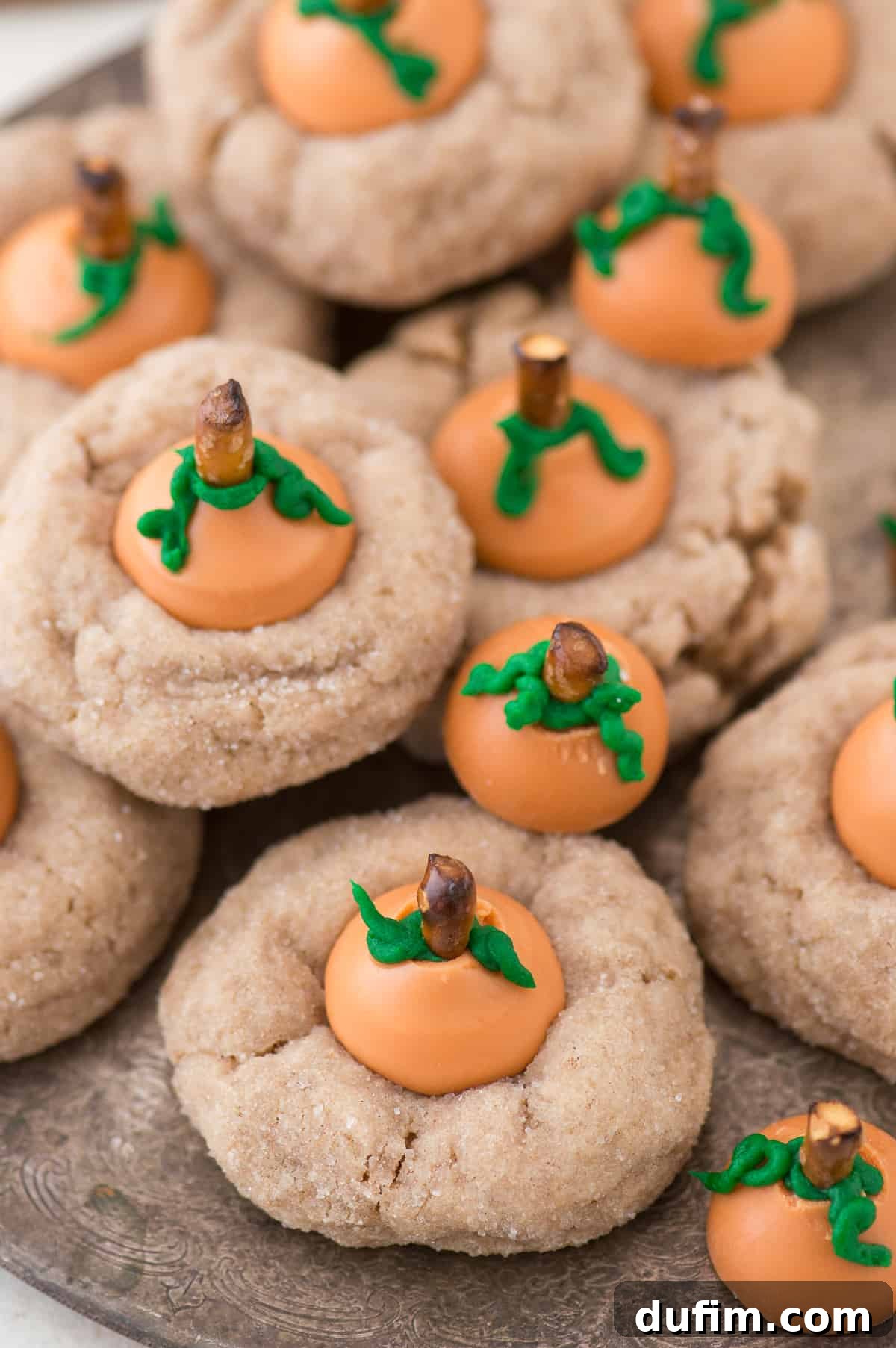 Pumpkin Blossom Delights 5 A baking sheet filled with golden-brown pumpkin blossom cookies, some with their Kisses melting, others awaiting decoration, showcasing the warm, inviting texture.