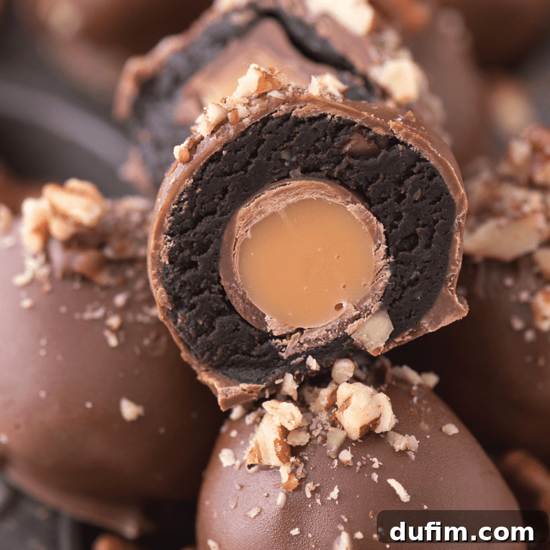 Decadent Turtle Oreo Truffles 11 Close-up of a chocolate-dipped Oreo ball with Rolo candy inside, garnished with a pecan
