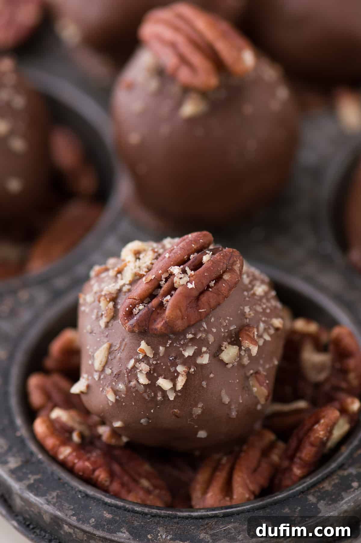 Decadent Turtle Oreo Truffles 4 Three prepared Oreo balls covered in chocolate with a whole pecan on top