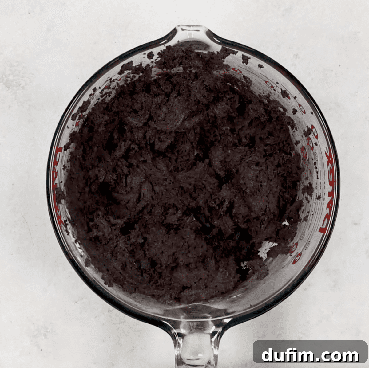 Oreo crumbs and softened cream cheese being mixed together in a glass bowl to form the truffle base.