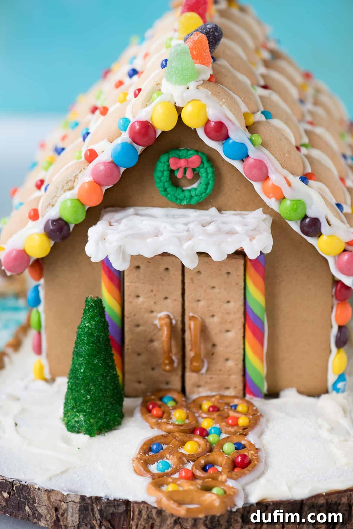 Close-up of a gingerbread house's candy roof with colorful sprinkles and a whimsical design.