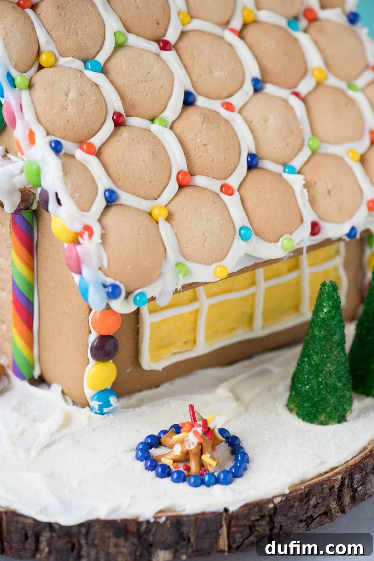 A festive gingerbread house scene featuring a pretzel fence, candy decorations, and a snowy landscape.