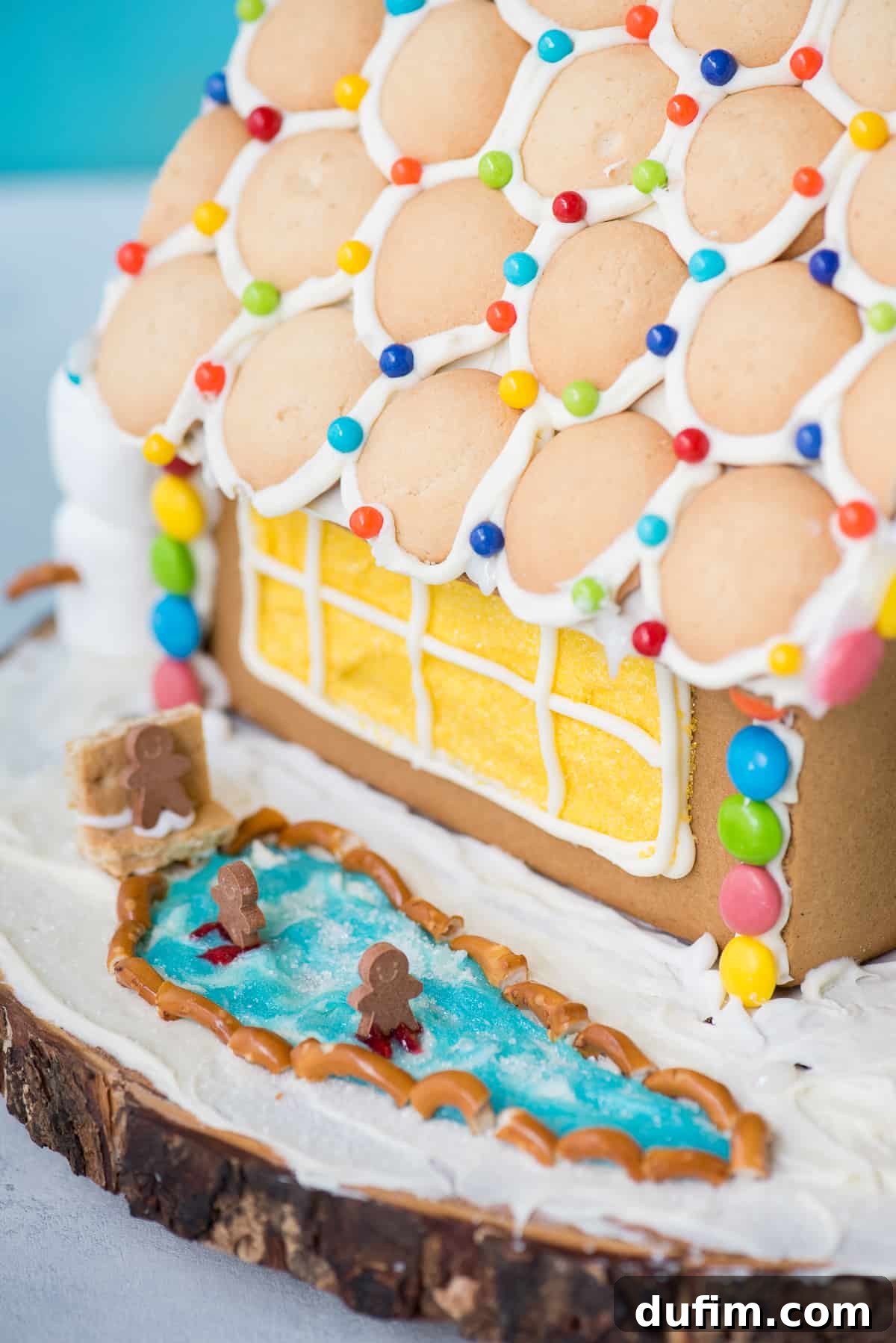 A gingerbread house wall being carefully assembled, showing the interior structure and initial adhesion.