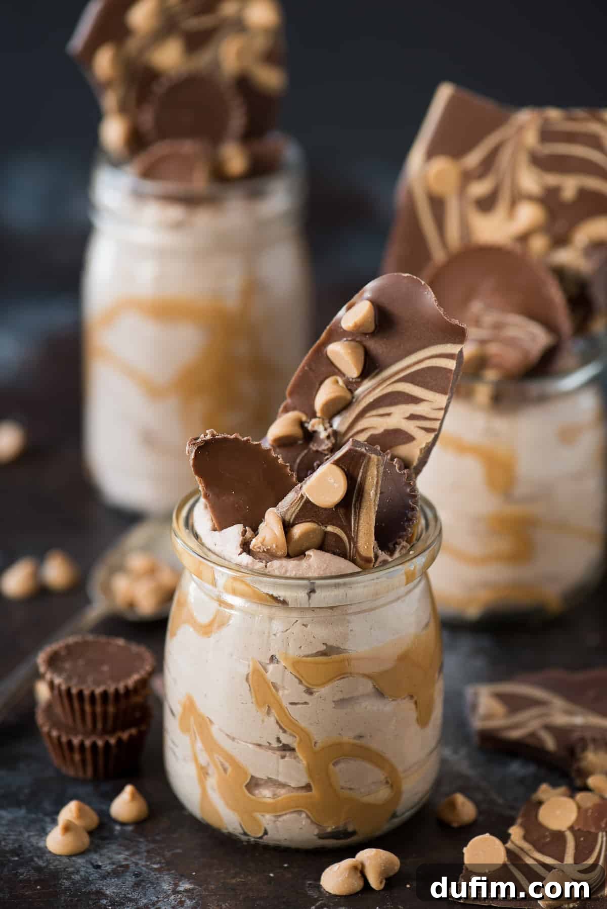 Decadent and fluffy chocolate peanut butter mousse jars, garnished with chocolate bark and peanut butter chips.