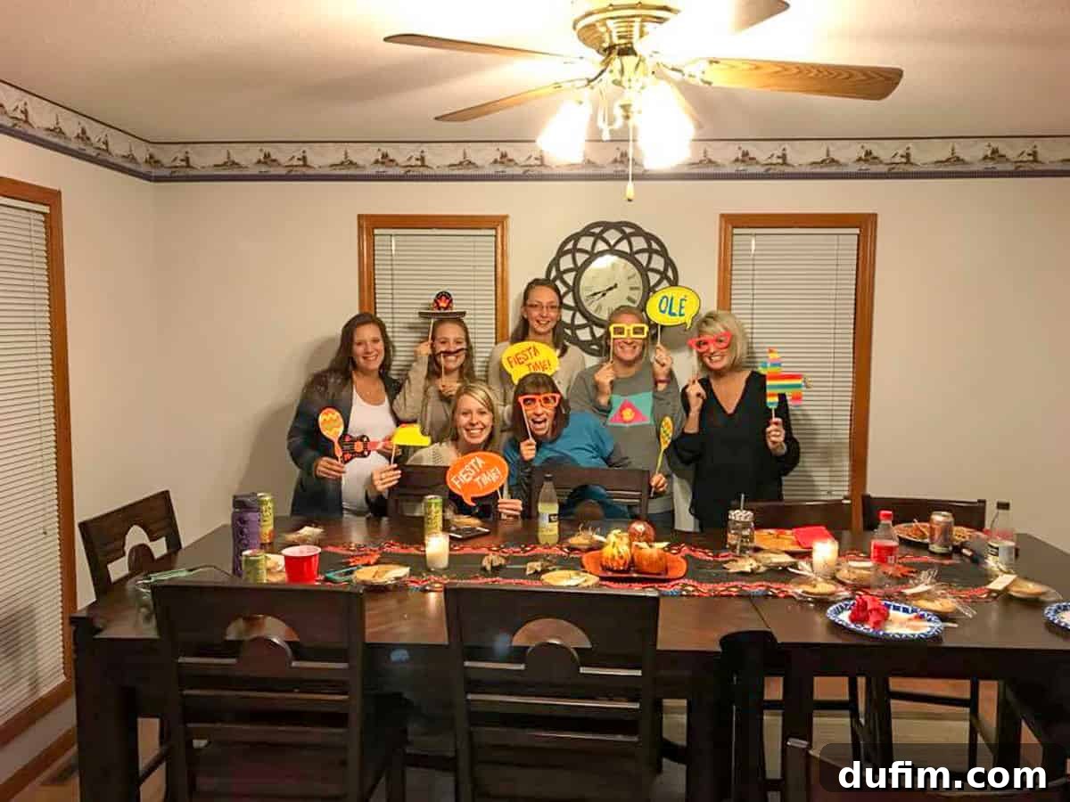 November's Gastronomic Adventures 6 A group of people gathered at a table for a Thanksgiving fiesta, smiling and enjoying themselves.