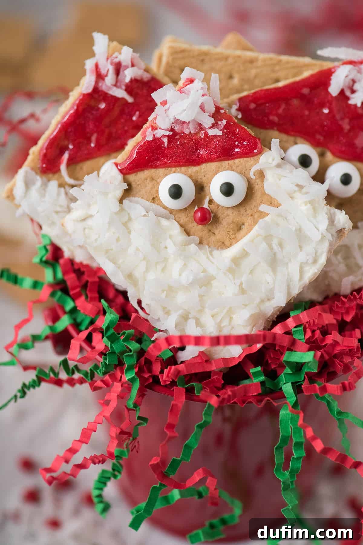 Festive graham cracker squares decorated with frosting to look like Santa Claus, perfect for holiday crafting.