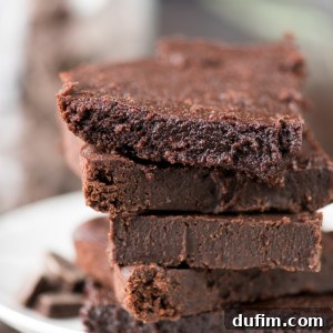Five homemade healthier fudgy brownies on a white serving plate.
