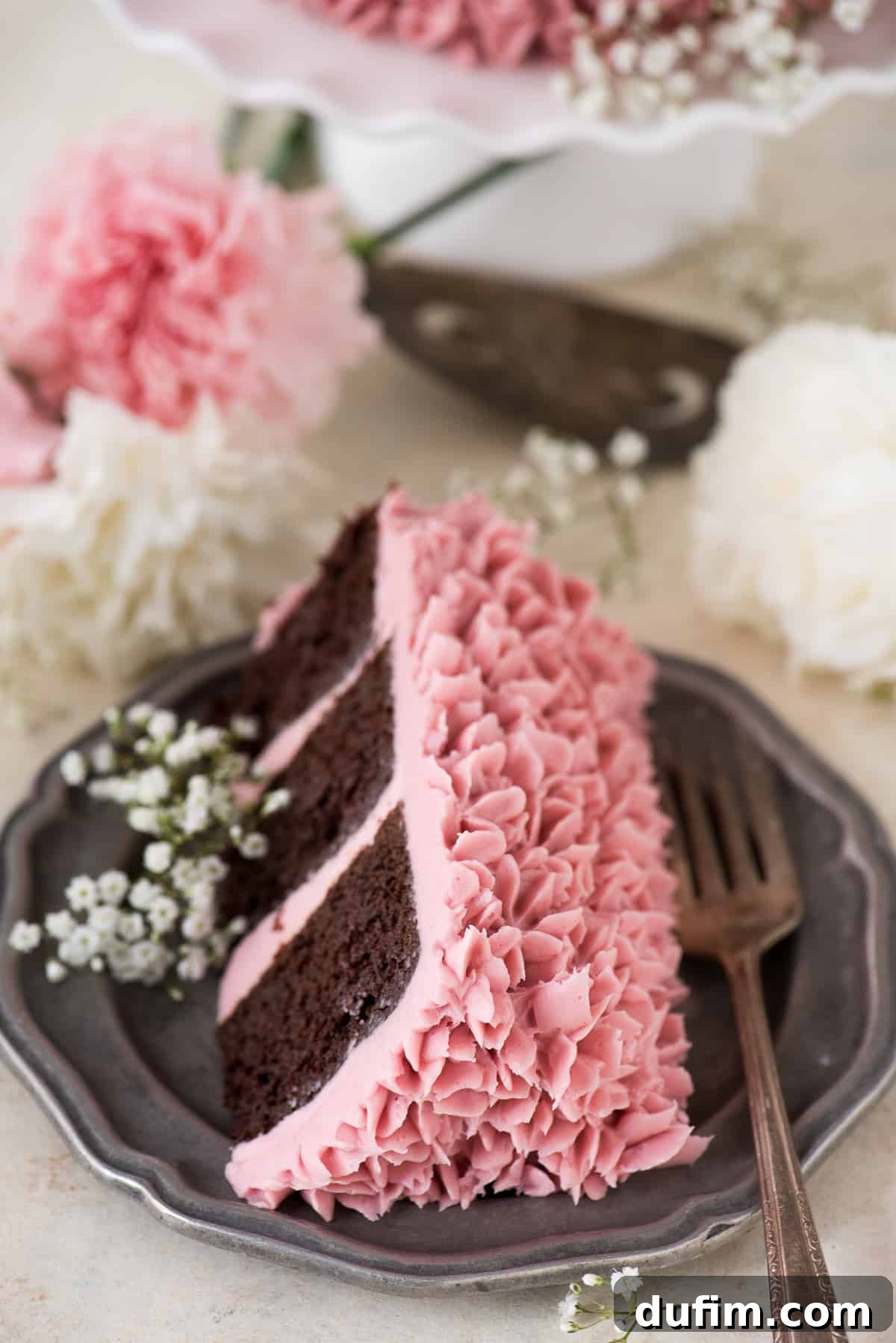 Crimson Raspberry Chocolate Torte 4 Side view of the decorated raspberry chocolate cake, showcasing the layers and floral garnishes