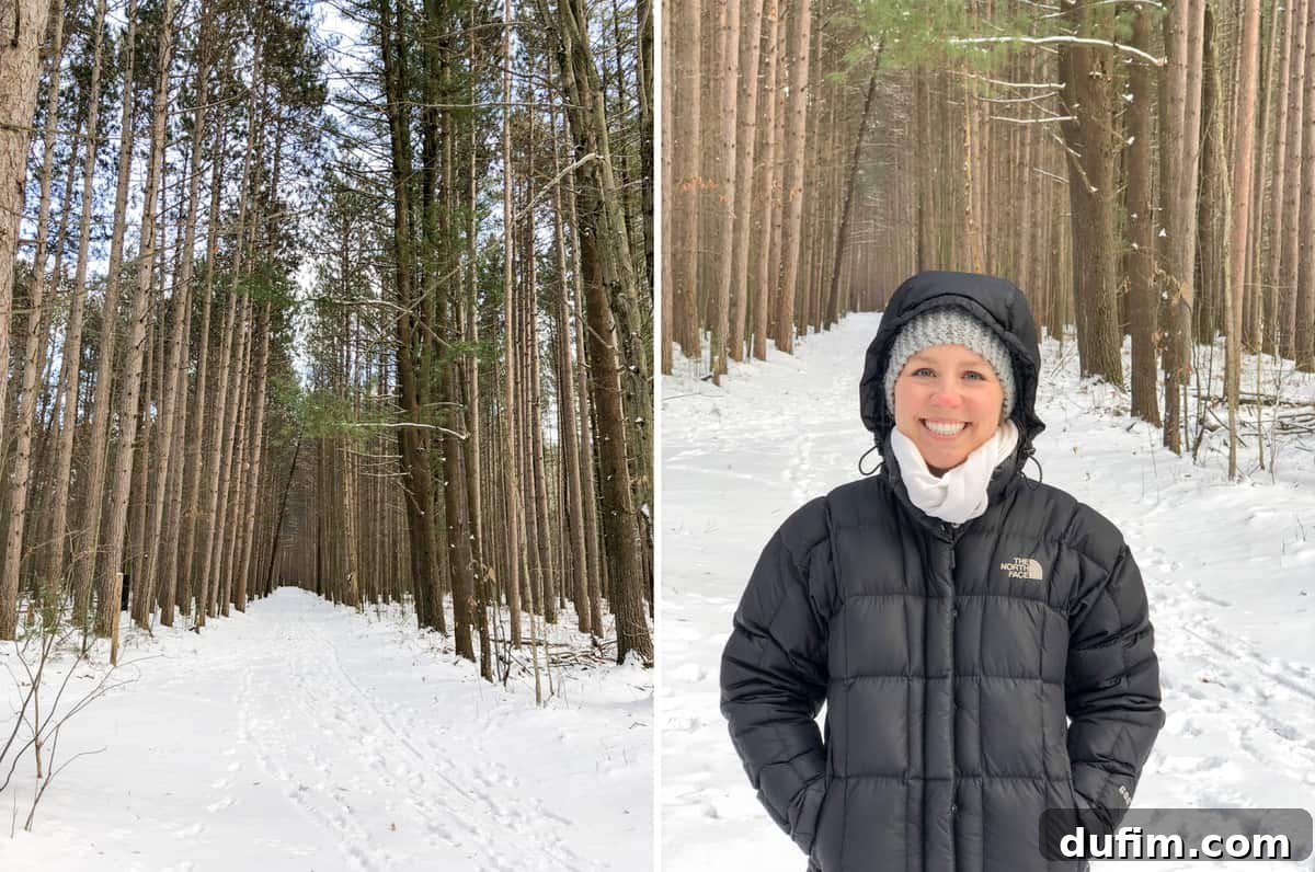 A serene snowy forest path during a winter walk, with tall trees covered in a blanket of snow.