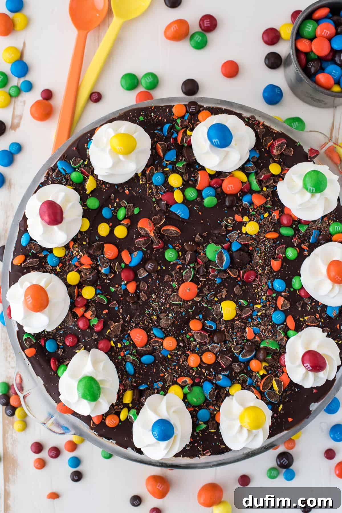 M&M No-Bake Dream Pie 3 Close-up of the No-Bake M&M Pie showcasing the defined layers of dark chocolate Oreo crust, creamy light brown peanut butter filling, and the colorful M&M candies sprinkled on top.