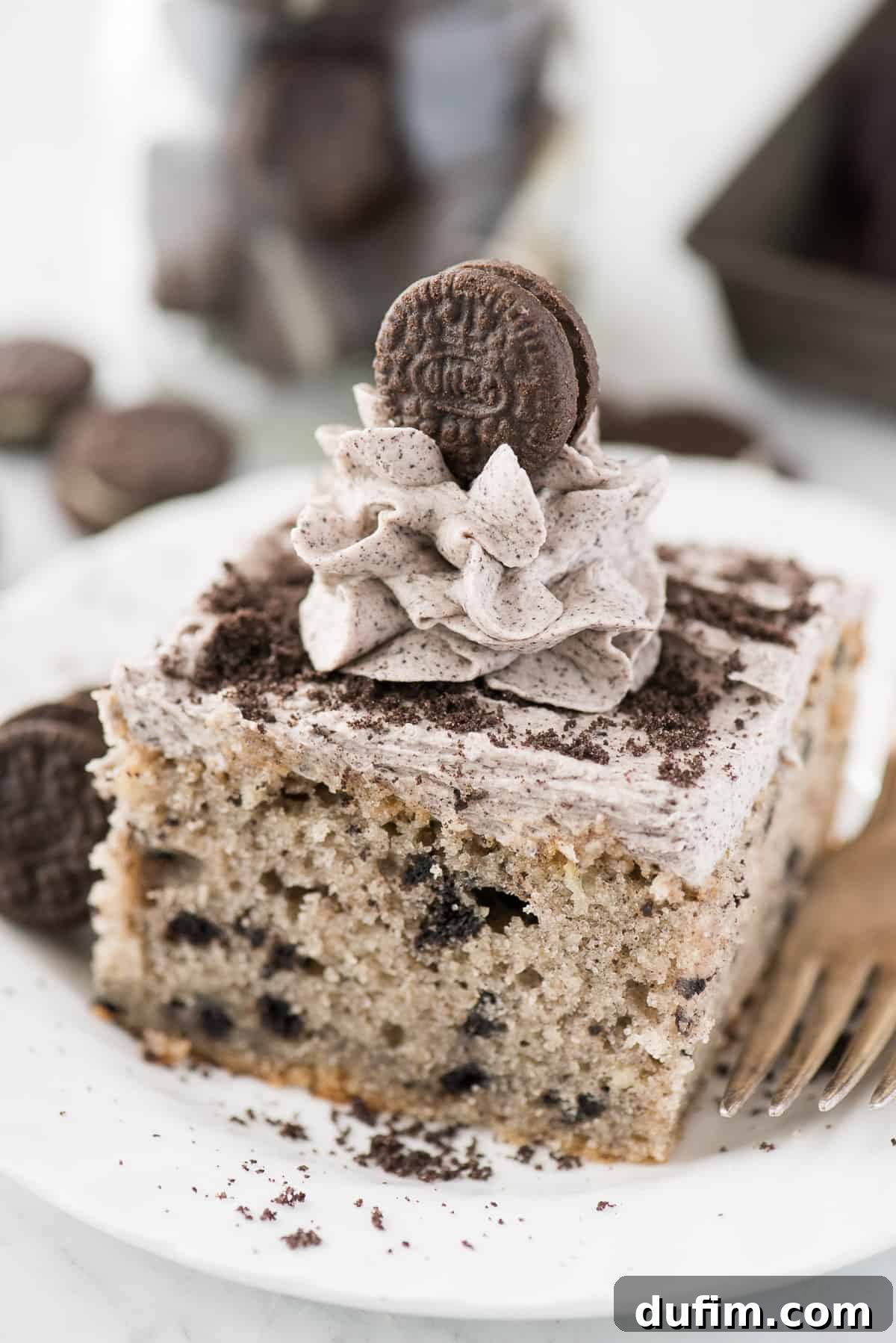 A slice of cookies and cream Oreo cake on white plate