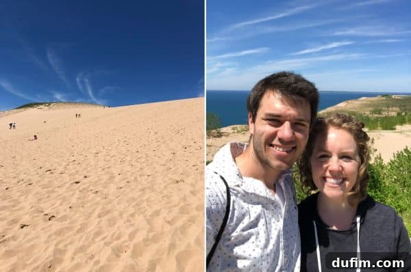 Couple standing atop the vast sandy hills of Sleeping Bear Dunes with Lake Michigan in the background