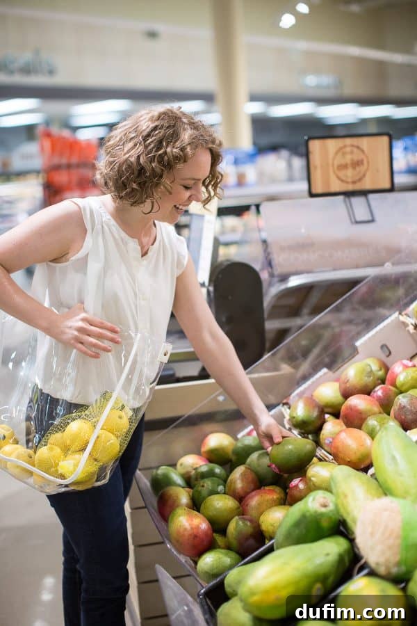 woman shopping for mango in a grocery store, genuinely smiling for brand photos