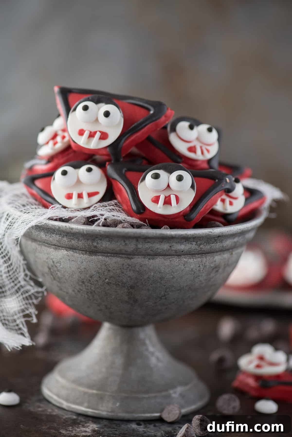 Close-up of easy-to-make vampire treats crafted from graham crackers and candy melts, arranged enticingly in a metal bowl, ready for a festive Halloween celebration
