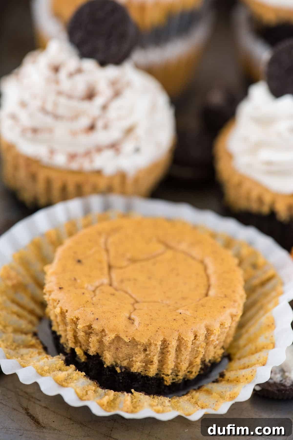 Mini pumpkin cheesecake with oreo cookie crust in muffin liner