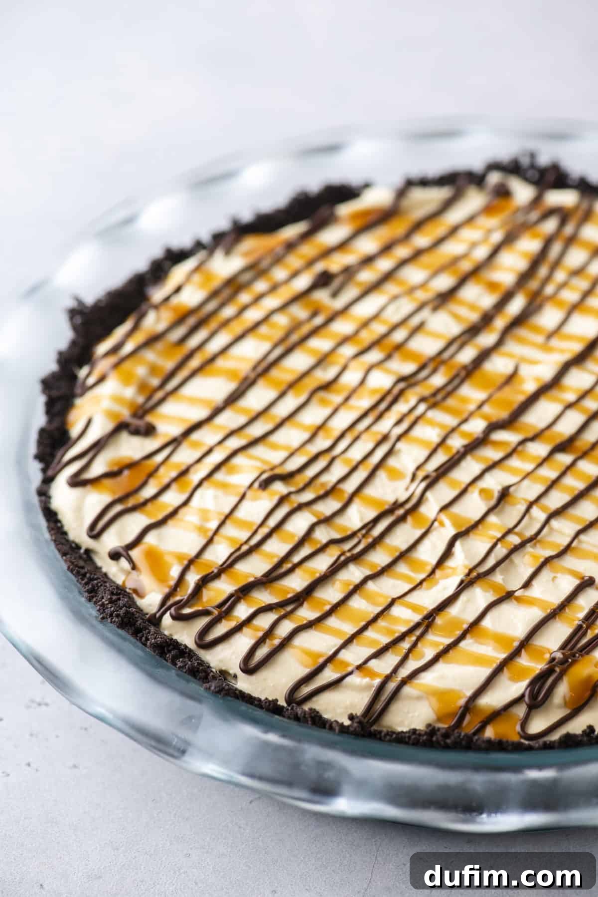 Caramel Pecan Chocolate Indulgence 7 A close-up view of the no-bake Turtle Pie, with its smooth, chilled filling and initial drizzles of chocolate and caramel, ready for the final layer of whipped cream and pecans.