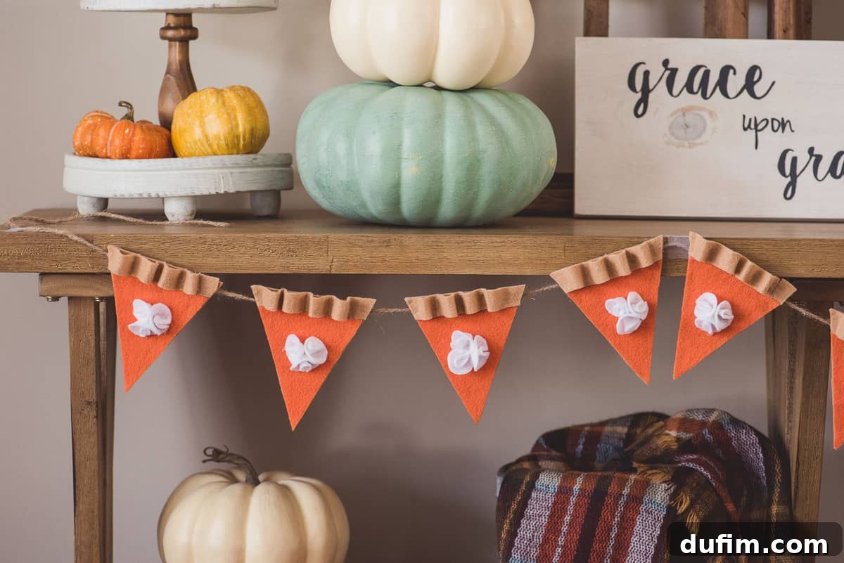 Close-up of Festive DIY Felt Pumpkin Pie Garland Decor Close-up of a DIY felt pumpkin pie garland showcasing the festive details and cozy ambiance for holiday decorating.