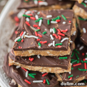 Close-up of stacked toffee squares topped with a layer of chocolate and decorated with red, white, and green sprinkles, giving a festive holiday appearance.