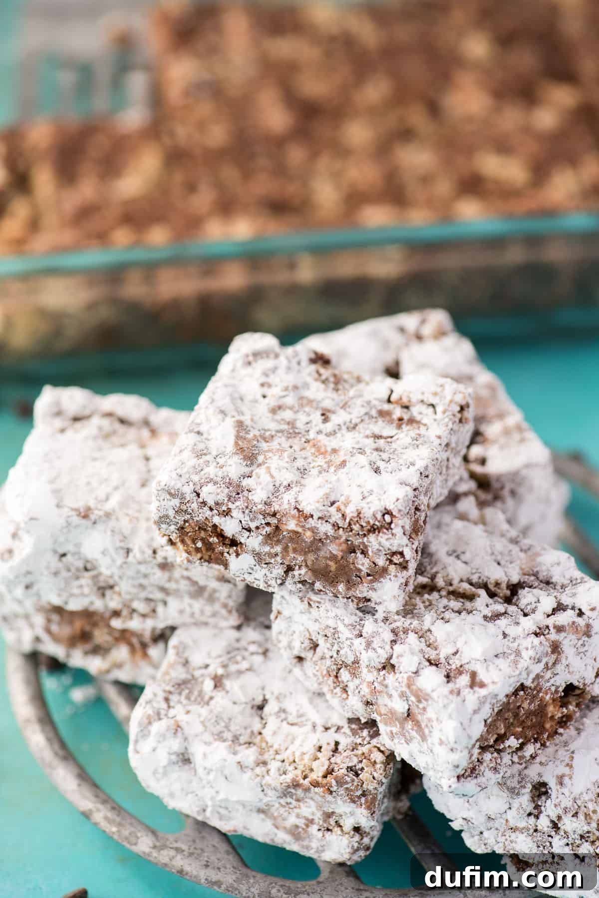 A generous pile of Puppy Chow Bars neatly arranged on a rustic metal tray.