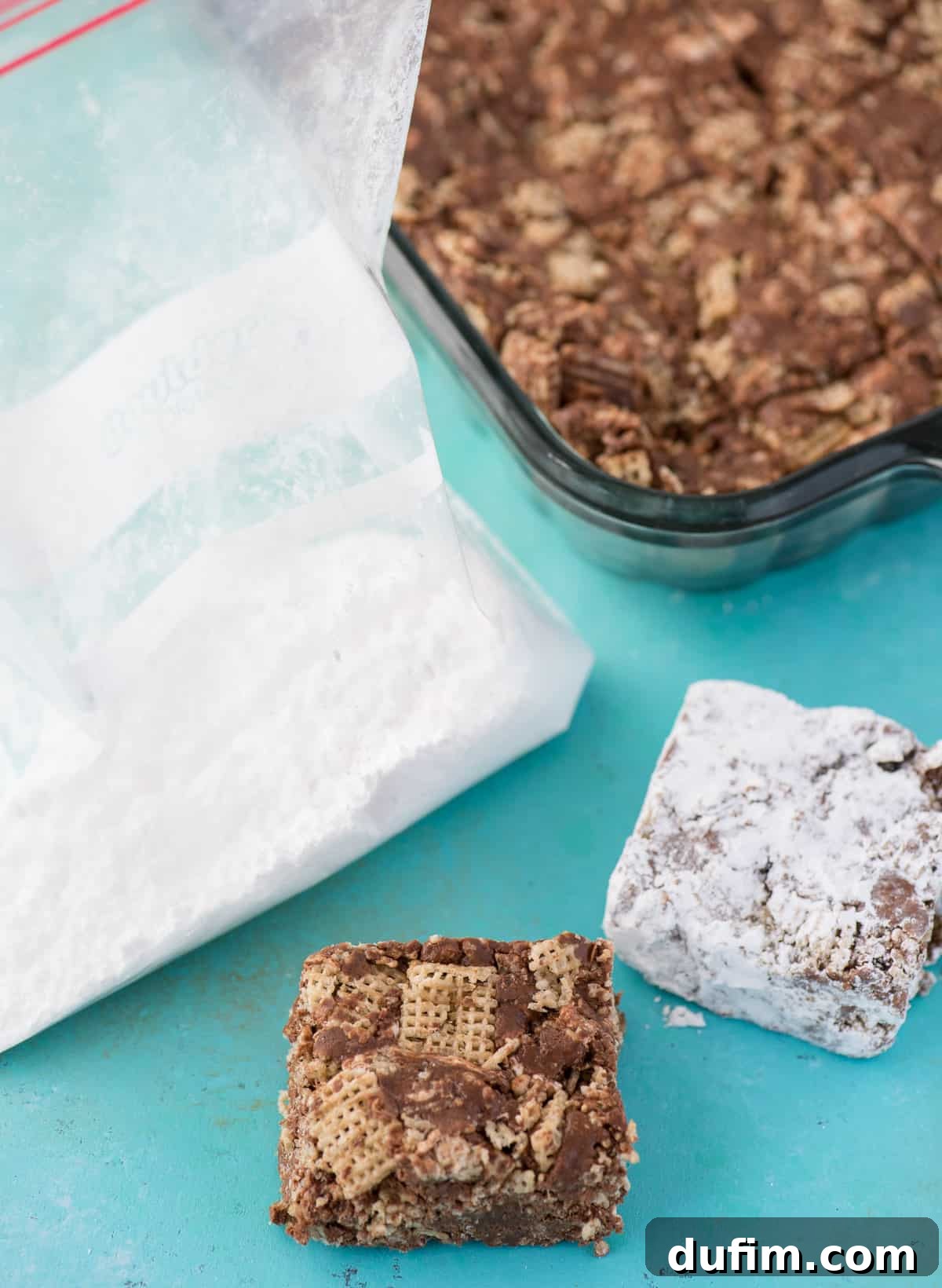 Puppy Chow Bars displayed alongside a bag of powdered sugar, highlighting the finishing touch.